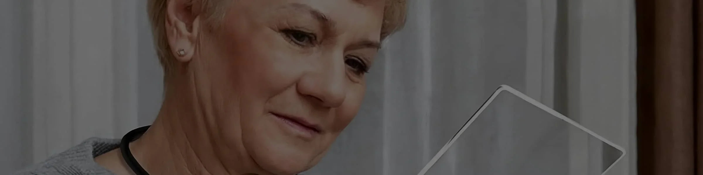 Femme malvoyante lisant avec une loupe DMLA electronique