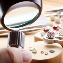 Image d'une loupe de bijoutier utilisée pour examiner des bijoux, illustrant des techniques professionnelles dans un environnement réaliste et bien éclairé.